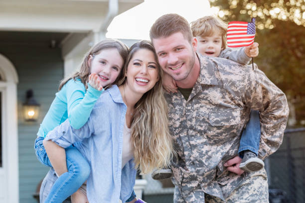 A military family including a father wearing an army combat uniform, a mother, and two children