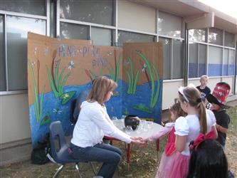 students gathered around ping pong pond table